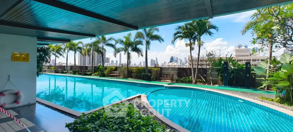 Luxurious rooftop pool with stunning city skyline view and lush greenery.