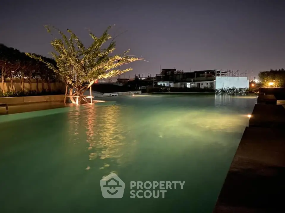 Serene night-time view of a luxurious pool area with ambient lighting, perfect for evening relaxation and social gatherings in a high-end residential complex.