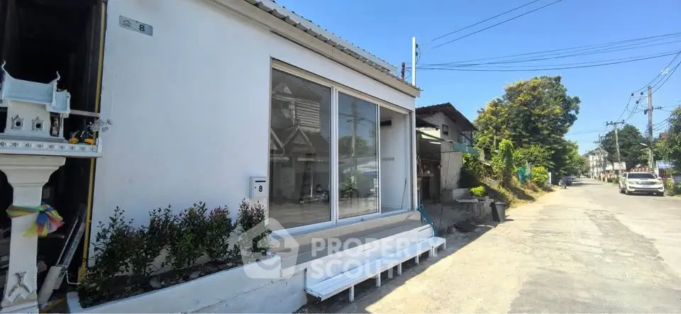 Charming residential street view with modern white house and lush greenery