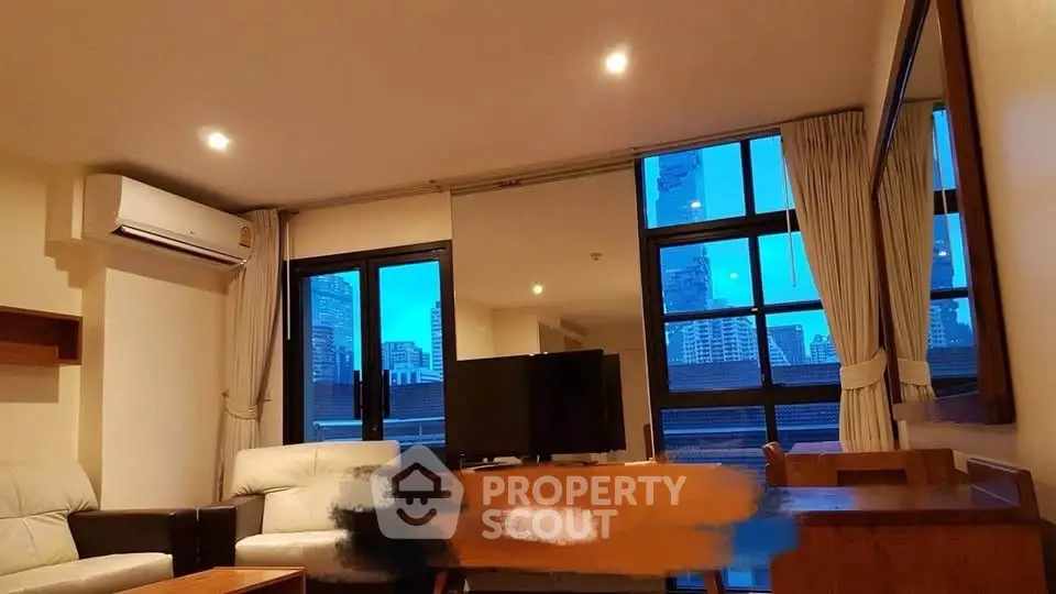 Spacious living room with city view, modern furniture, and large windows in a high-rise apartment.