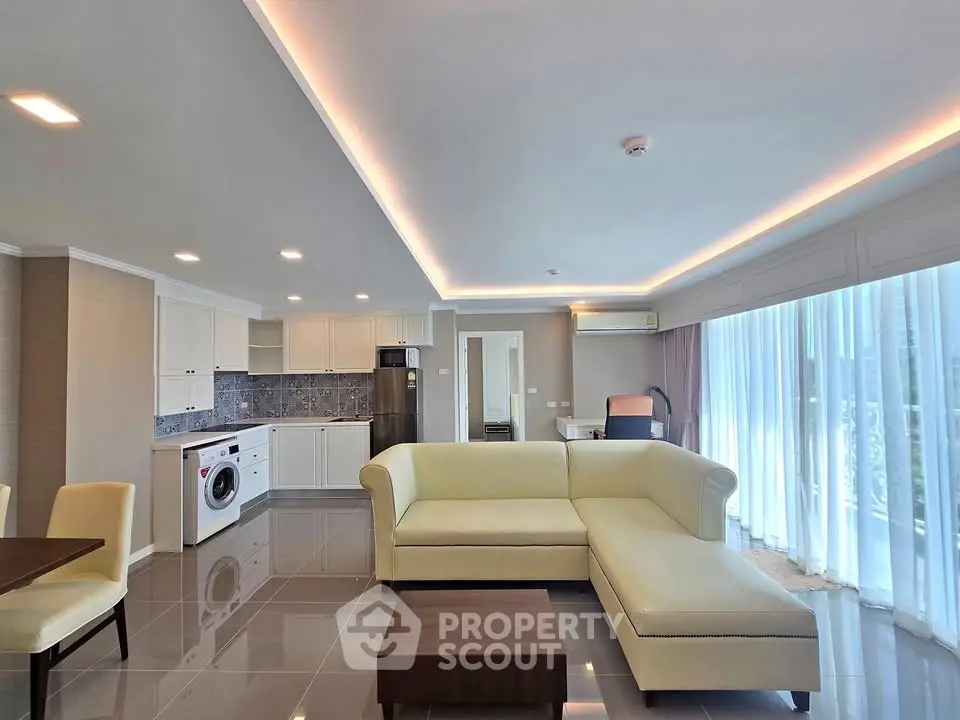 Spacious modern living room with open kitchen and elegant lighting