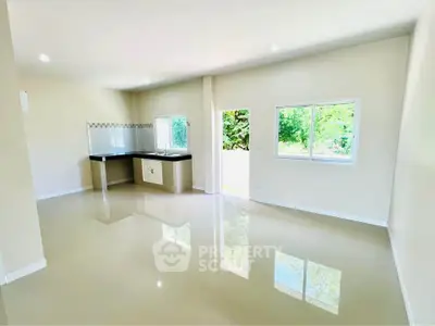 Spacious open-plan living area with modern kitchen and large windows