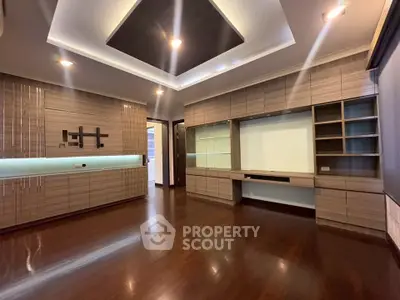 Spacious modern living room with elegant wood paneling and built-in shelving, perfect for stylish urban living.