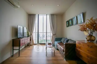 Spacious living room with large window and stylish decor in modern apartment.