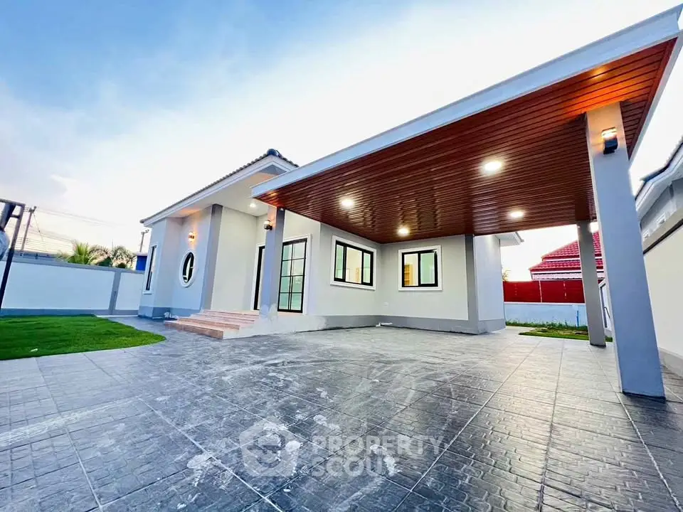 Modern single-story house with spacious driveway and stylish exterior lighting.