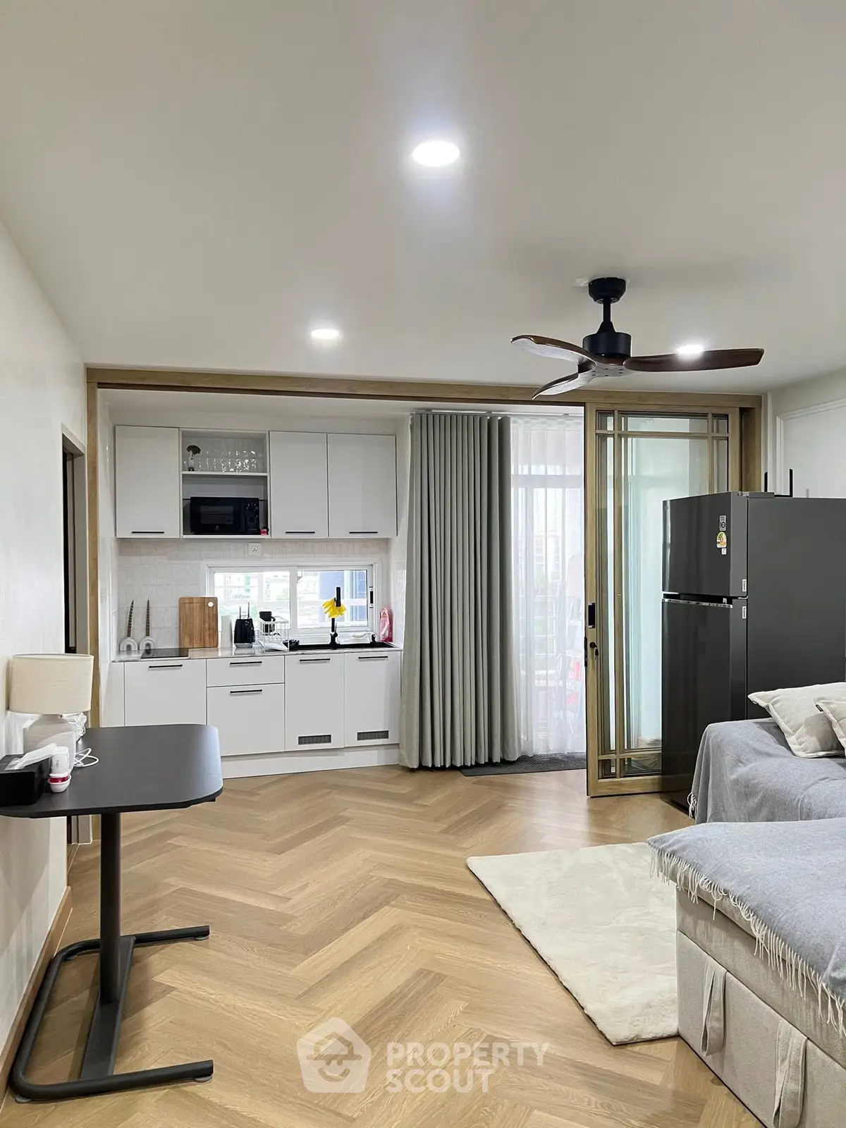 Modern studio apartment with open kitchen and cozy living area, featuring sleek appliances and stylish decor.