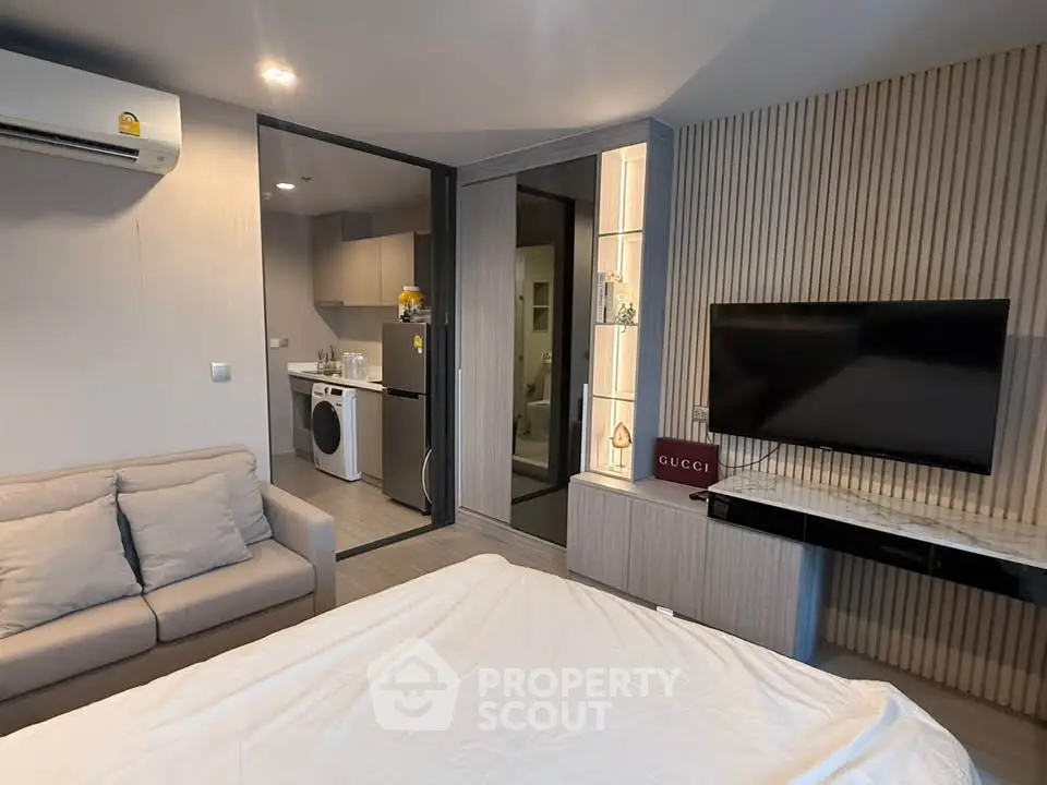 Modern studio apartment with open layout, featuring a cozy living area, sleek kitchen, and stylish decor.