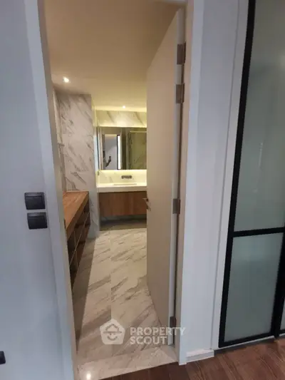 Modern bathroom with marble flooring and sleek wooden cabinetry