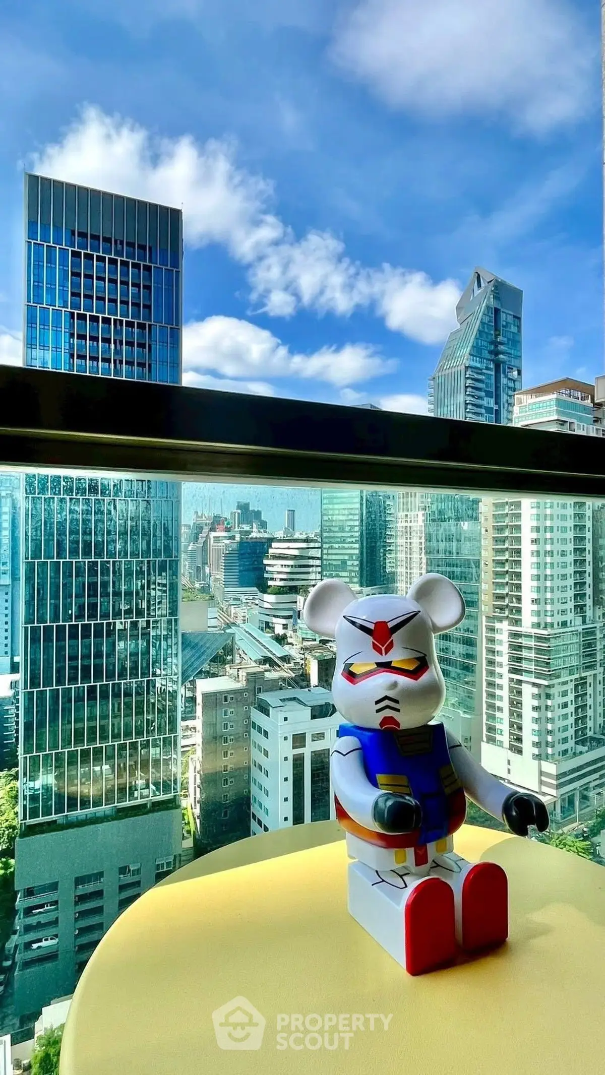 Stunning cityscape view from a modern high-rise balcony with unique decor.