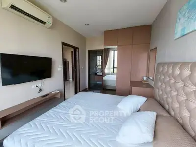 Modern bedroom with stylish decor and wall-mounted TV in a cozy apartment.