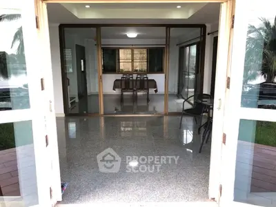 Spacious dining area with glass doors and polished flooring, perfect for family gatherings.