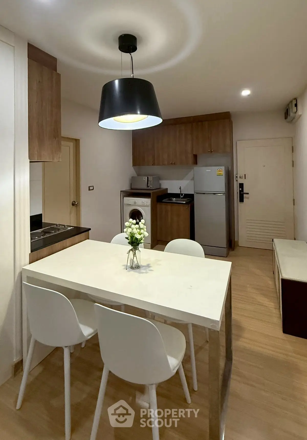 Modern kitchen with dining area, featuring sleek appliances and stylish lighting.