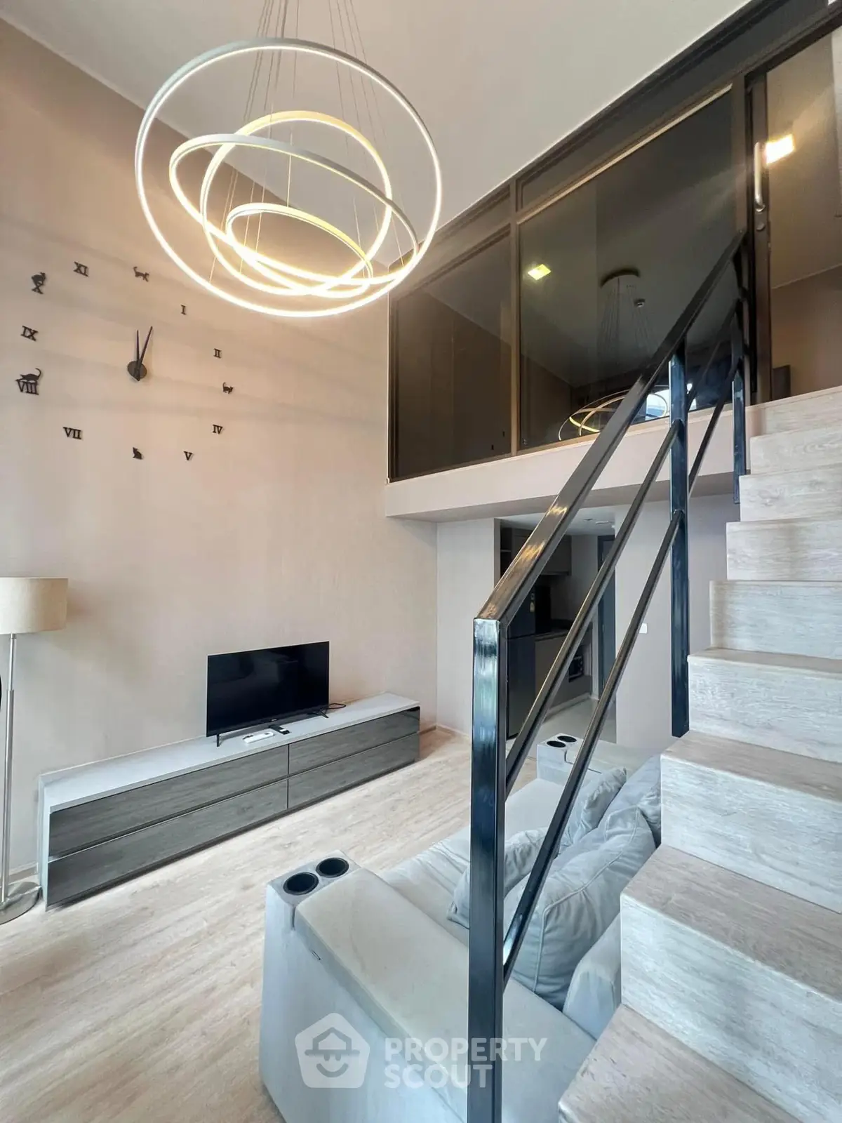 Modern living room with stylish staircase and unique wall clock design