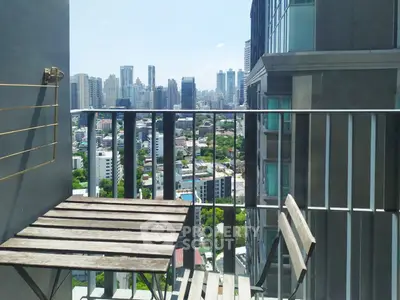 Stunning city view from a modern balcony with wooden furniture, perfect for urban living.