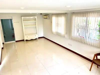 Spacious and bright living room with large windows and elegant tile flooring.