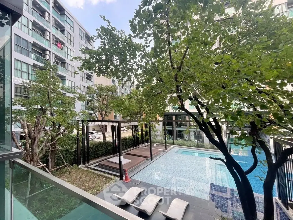 Modern apartment complex with pool and lush greenery, perfect for urban living.