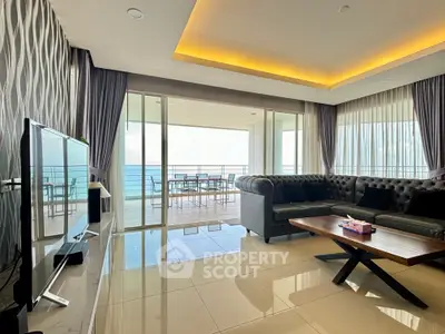 Luxurious living room with ocean view and spacious balcony, featuring modern decor and elegant lighting.