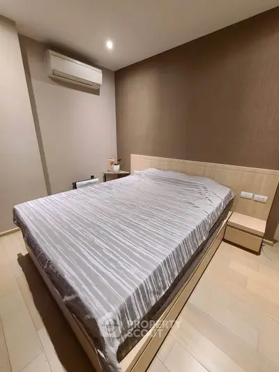 Modern bedroom with sleek design and air conditioning, featuring a comfortable bed and stylish decor.