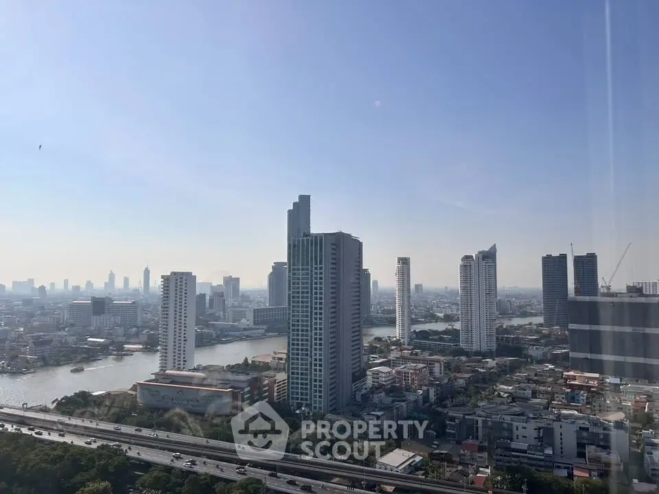 Stunning cityscape view from high-rise building showcasing urban skyline and river.