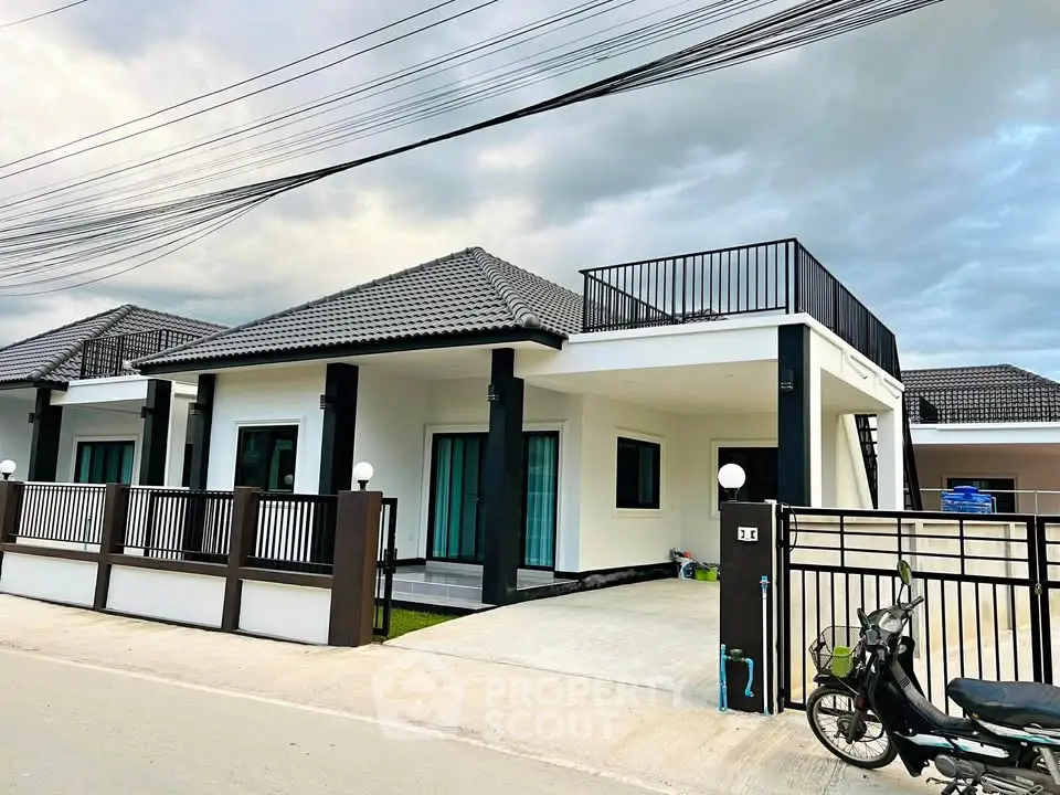 Modern single-story house with sleek design and spacious driveway in a serene neighborhood.