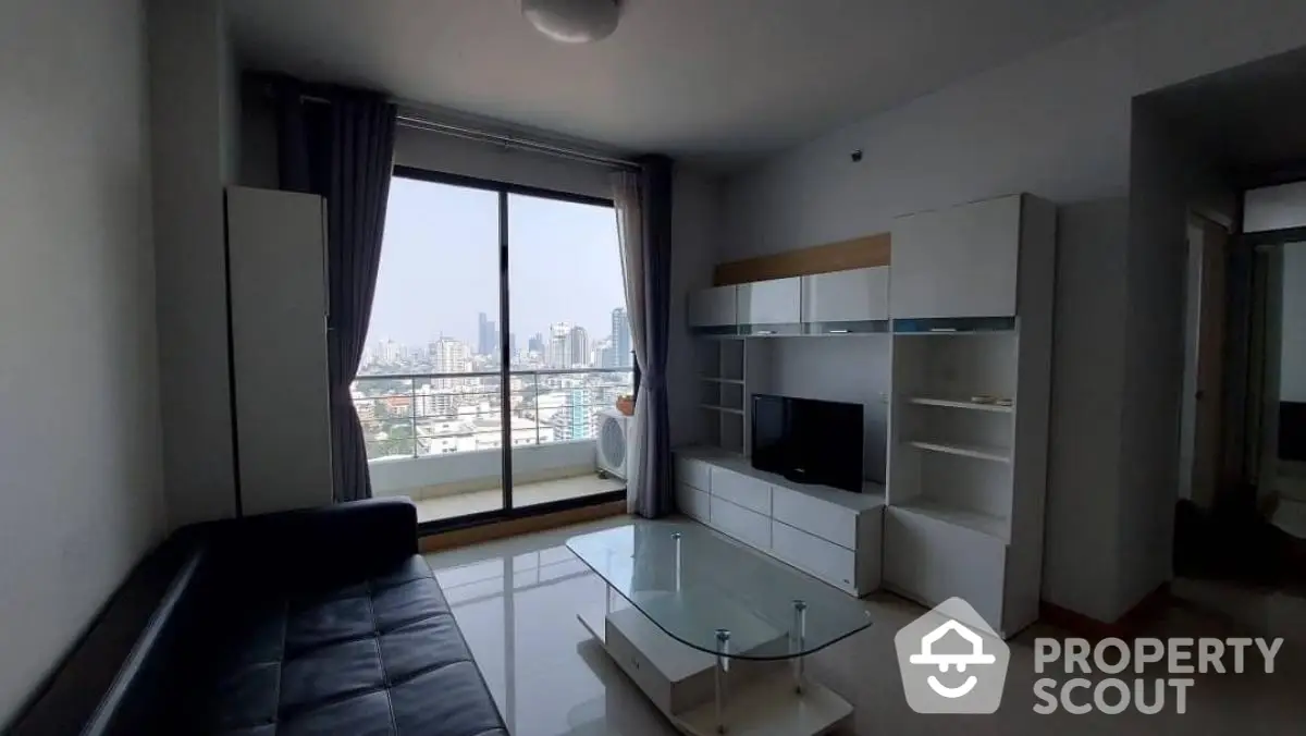 Modern living room with city view, sleek furniture, and large glass doors leading to balcony.