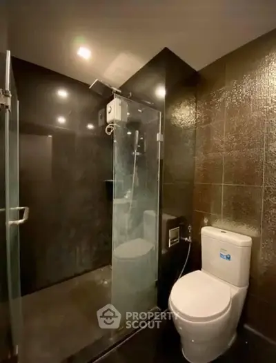 Modern bathroom with sleek black tiles and glass shower enclosure