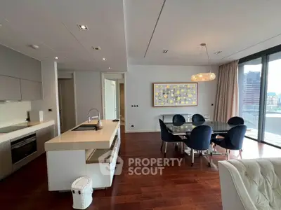 Luxurious open-plan living room with modern kitchen and stunning city view balcony.