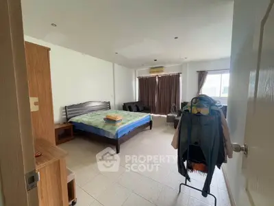 Spacious bedroom with natural light and modern furnishings in a cozy apartment.