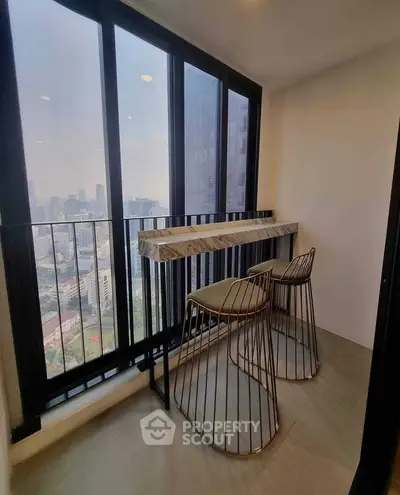 Chic urban balcony with stunning city view and modern seating, perfect for relaxation.