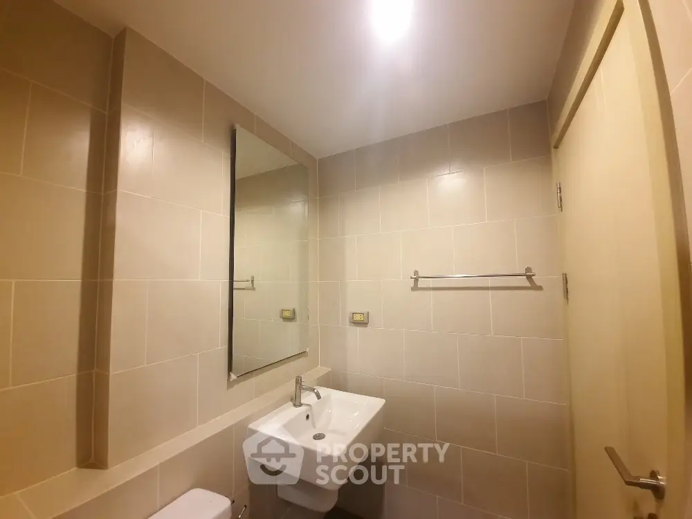 Modern bathroom with sleek fixtures and neutral tiles, perfect for a contemporary home.