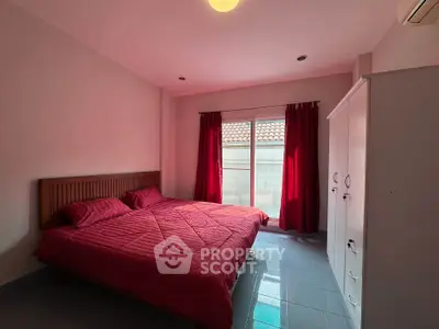 Cozy bedroom with red accents and natural light