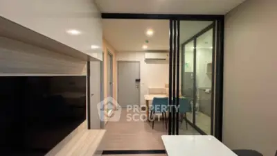 Modern apartment interior with glass partition and stylish dining area.