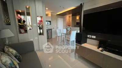Modern living room with sleek design and open kitchen layout, featuring elegant decor and ample natural light.