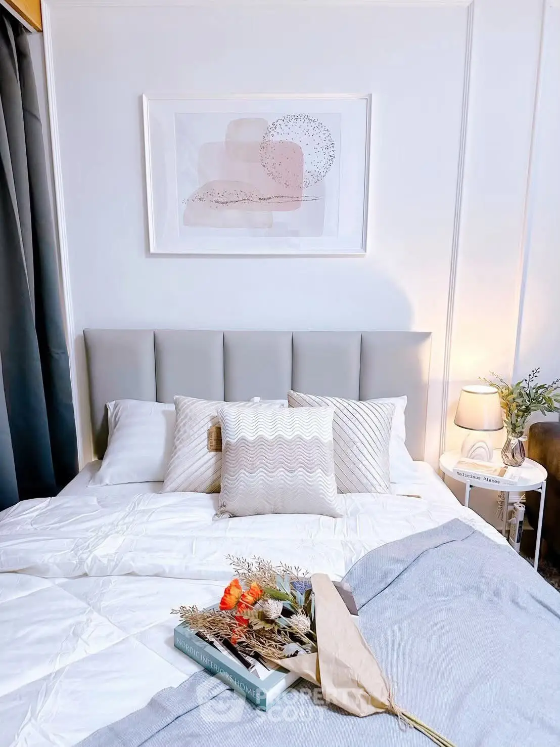 Cozy bedroom with modern decor, featuring a plush bed, stylish pillows, and elegant wall art.