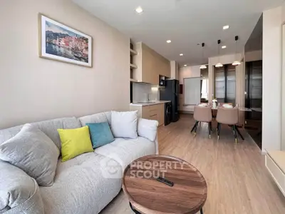 Modern living room with cozy sofa and stylish dining area in open layout apartment.