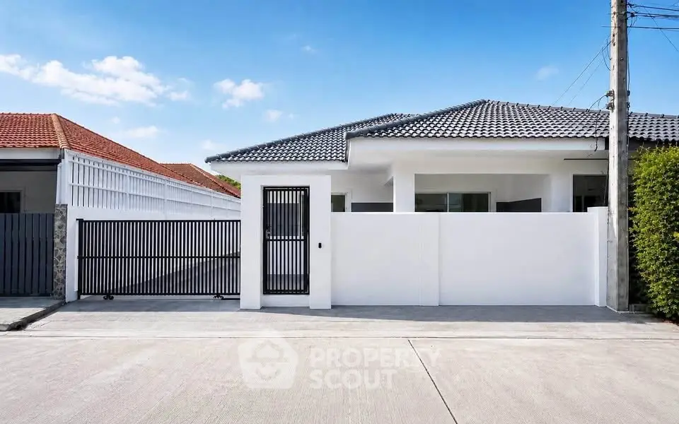 Modern single-story house with sleek design and gated entrance in a serene neighborhood.