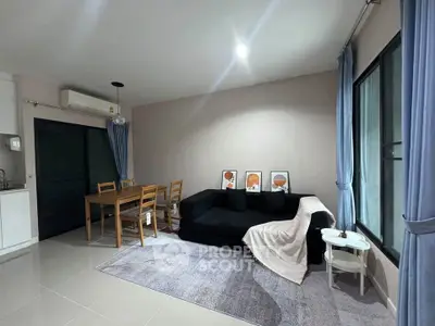 Modern living room with cozy black sofa and dining area in open layout