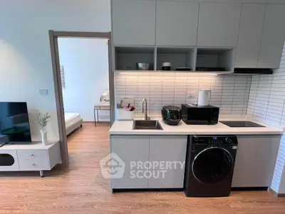 Modern open-layout kitchen with sleek appliances and cozy living area