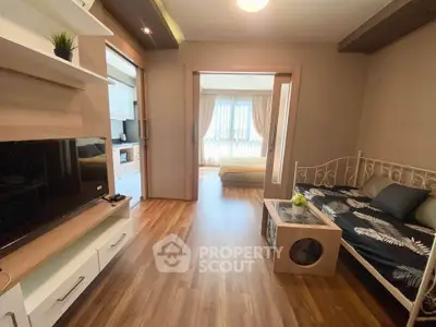Charming studio apartment with cozy living area and natural light, featuring modern decor and wooden flooring.