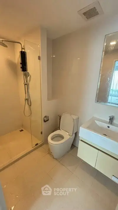Modern bathroom with glass shower and sleek fixtures in a contemporary apartment.