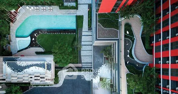 Stunning aerial view of modern apartment complex with pool and lush greenery.