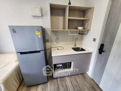 Compact modern kitchen with fridge and sink in cozy apartment