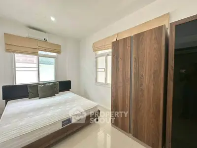 Modern bedroom with sleek wooden wardrobe and cozy bed in bright apartment