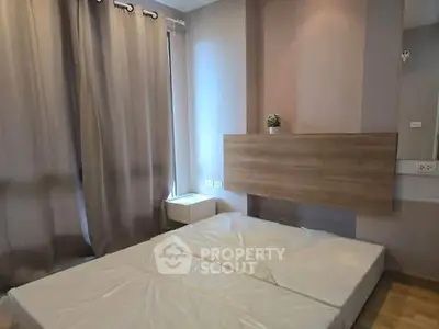 Modern bedroom with minimalist design and large window for natural light.