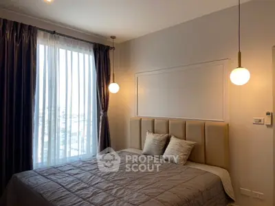 Elegant bedroom with modern lighting and large window with city view.