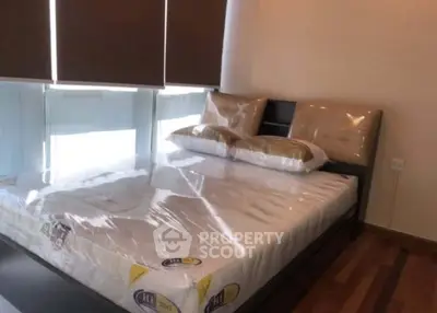 Modern bedroom with large windows and stylish decor, perfect for urban living.