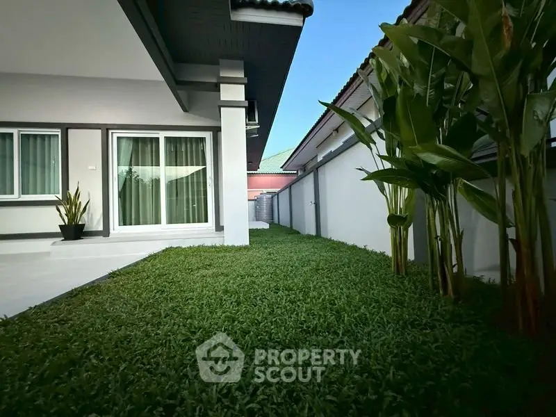 Charming modern home with lush green garden and sleek exterior design, perfect for tranquil living.