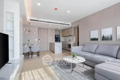 Modern living room with open kitchen, stylish decor, and natural light in a contemporary apartment.