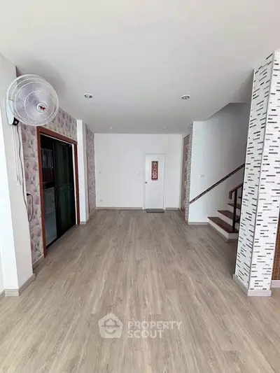 Spacious modern interior with elegant flooring and stylish staircase, perfect for contemporary living.