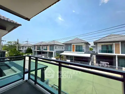 Spacious balcony with a view of modern suburban homes under a clear blue sky.